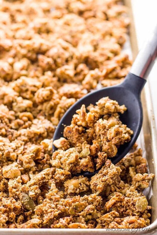 A sheet pan of low carb granola with a black spoon