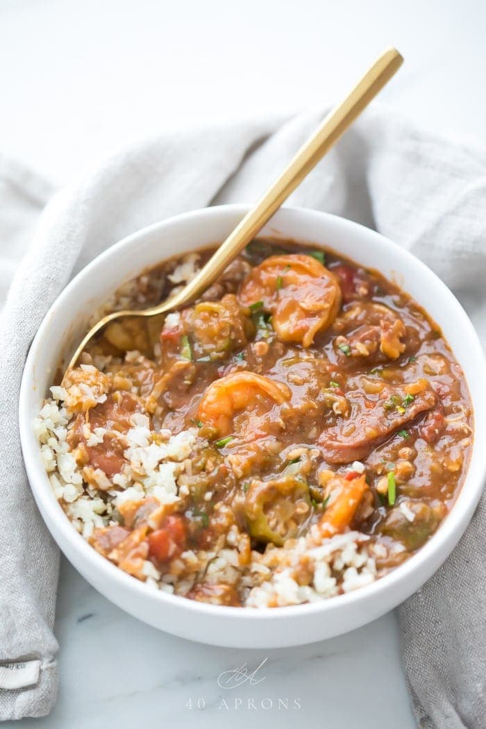 Paleo seafood gumbo in a white bowl with a gold spoon