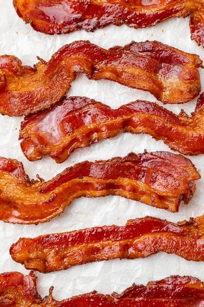 6 strips of air fried bacon on a sheet of parchment paper