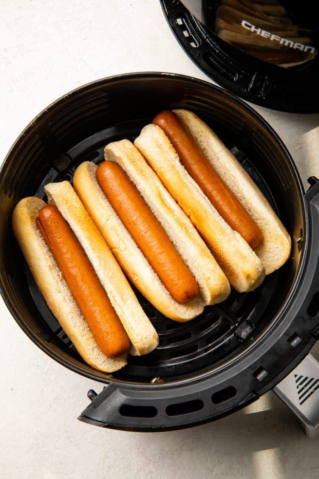 3 Hot dogs in buns in an air fryer basket