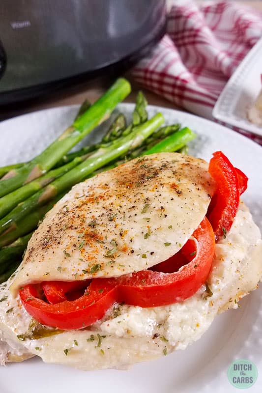 Chicken breast stuffed with tomato and cheese on a white bowl