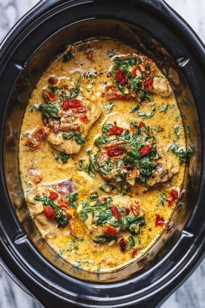 Tuscan chicken with spinach and sun-dried tomatoes in a crockpot bowl