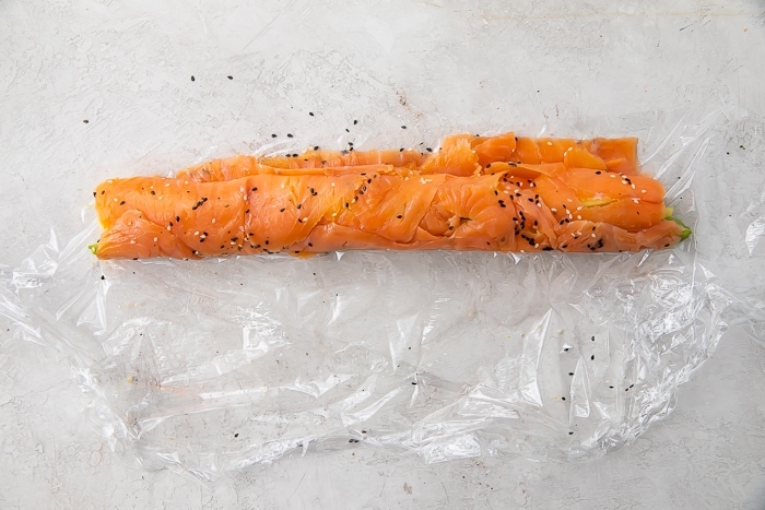 Salmon sushi roll on plastic wrap