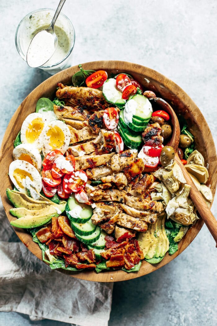 Paleo gluten free cobb salad in a wooden bowl with a wooden spoon