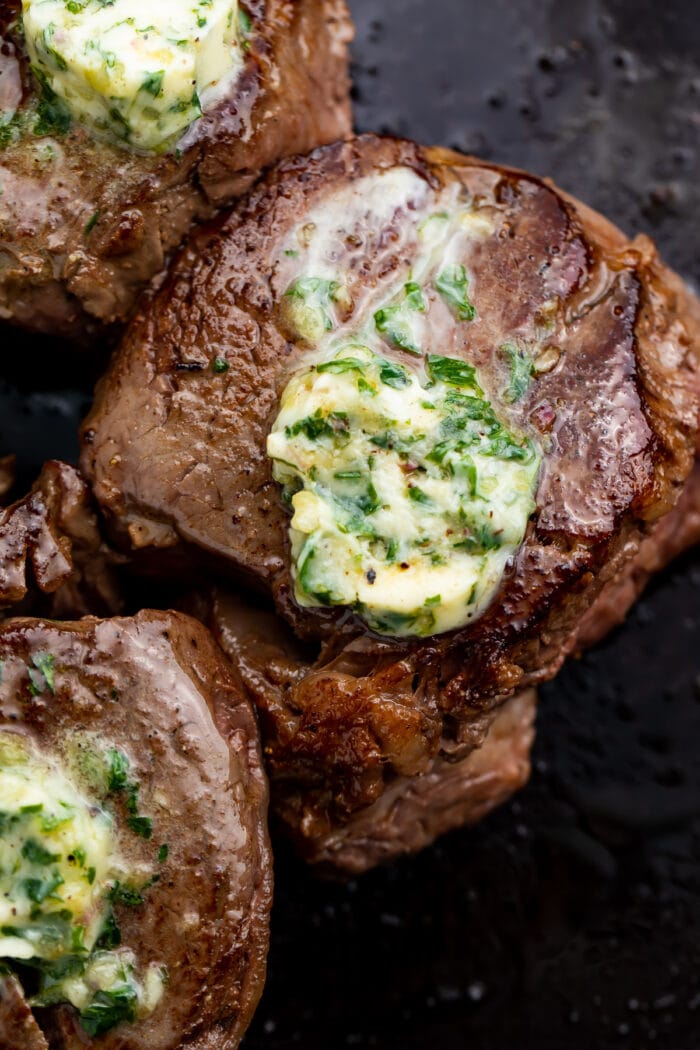 Overhead photo of filet mignon in a pan with garlic herb butter