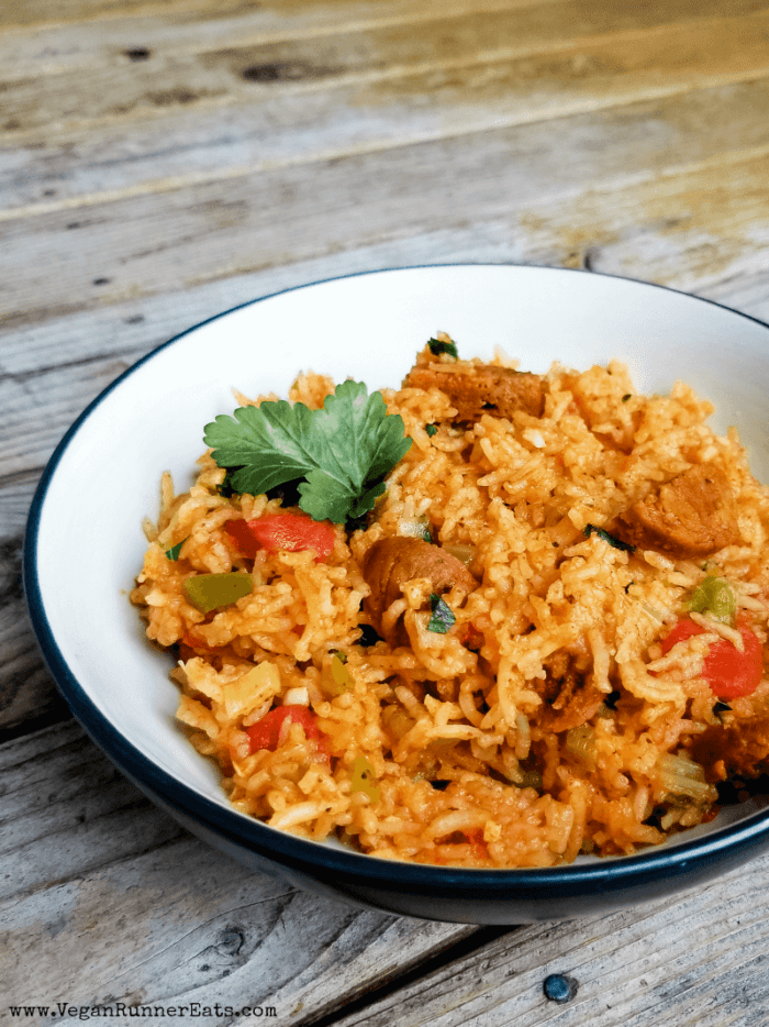 A shallow dish of vegan jambalaya on a wooden table