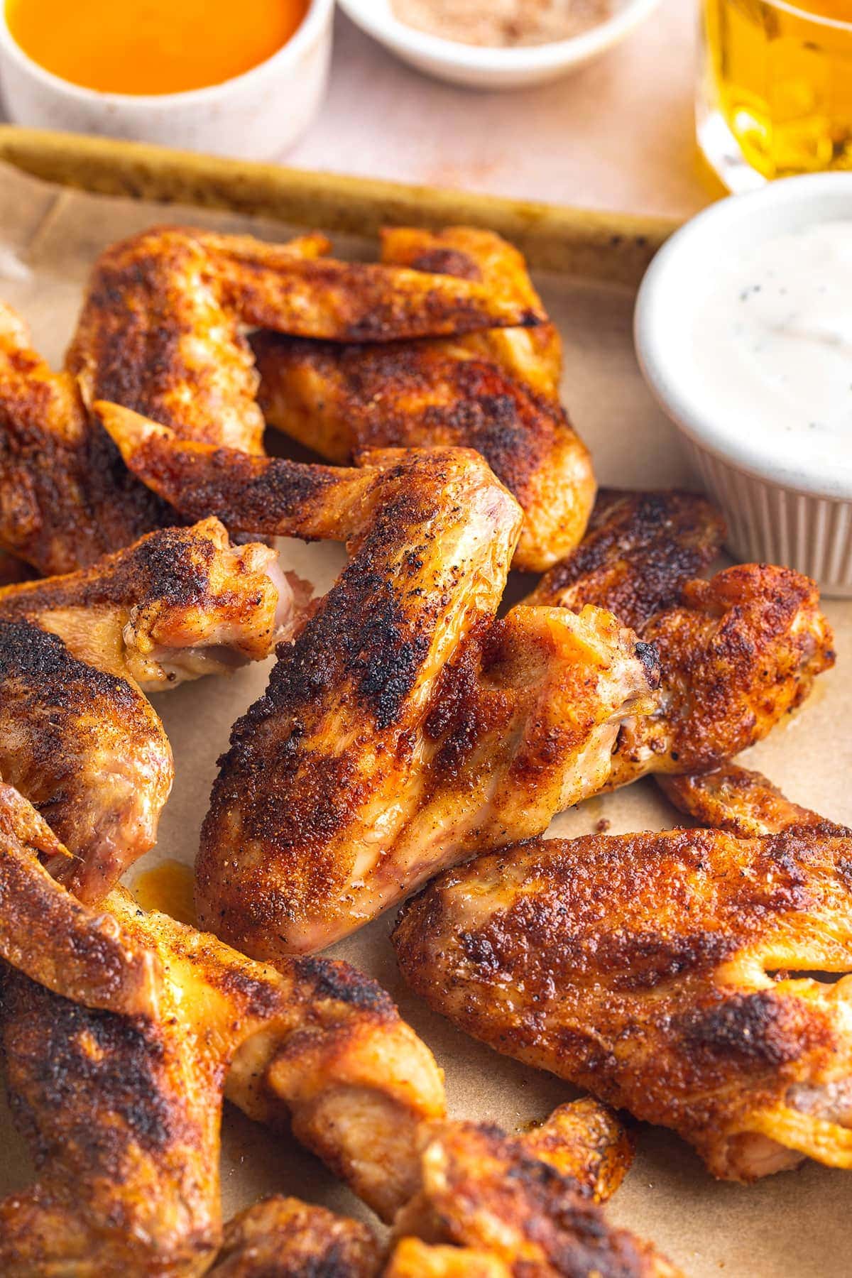 Crispy baked chicken wings seasoned with a simple dry rub and resting on a sheet pan lined with parchment paper.