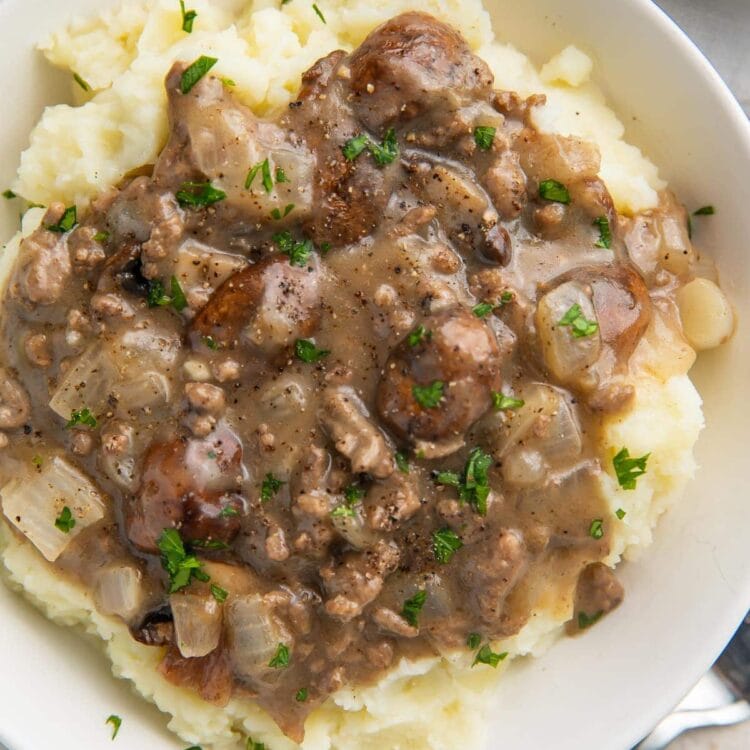 Close up overhead image of beef stroganoff on top of mashed potatoes