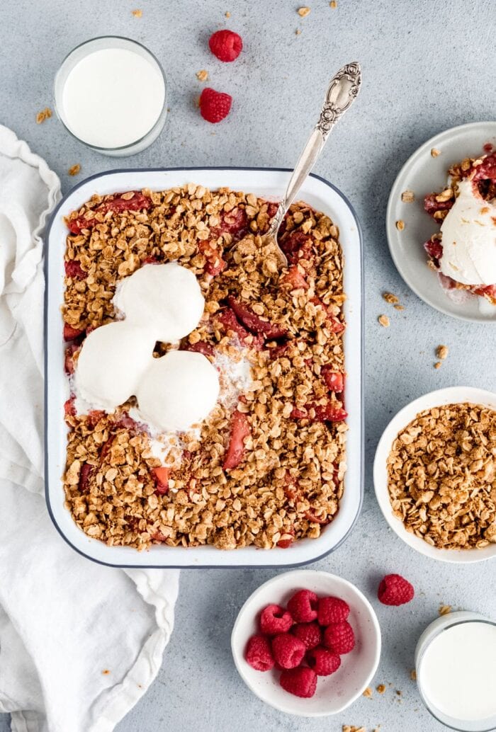 A casserole dish of peach berry crisp with vegan ice cream