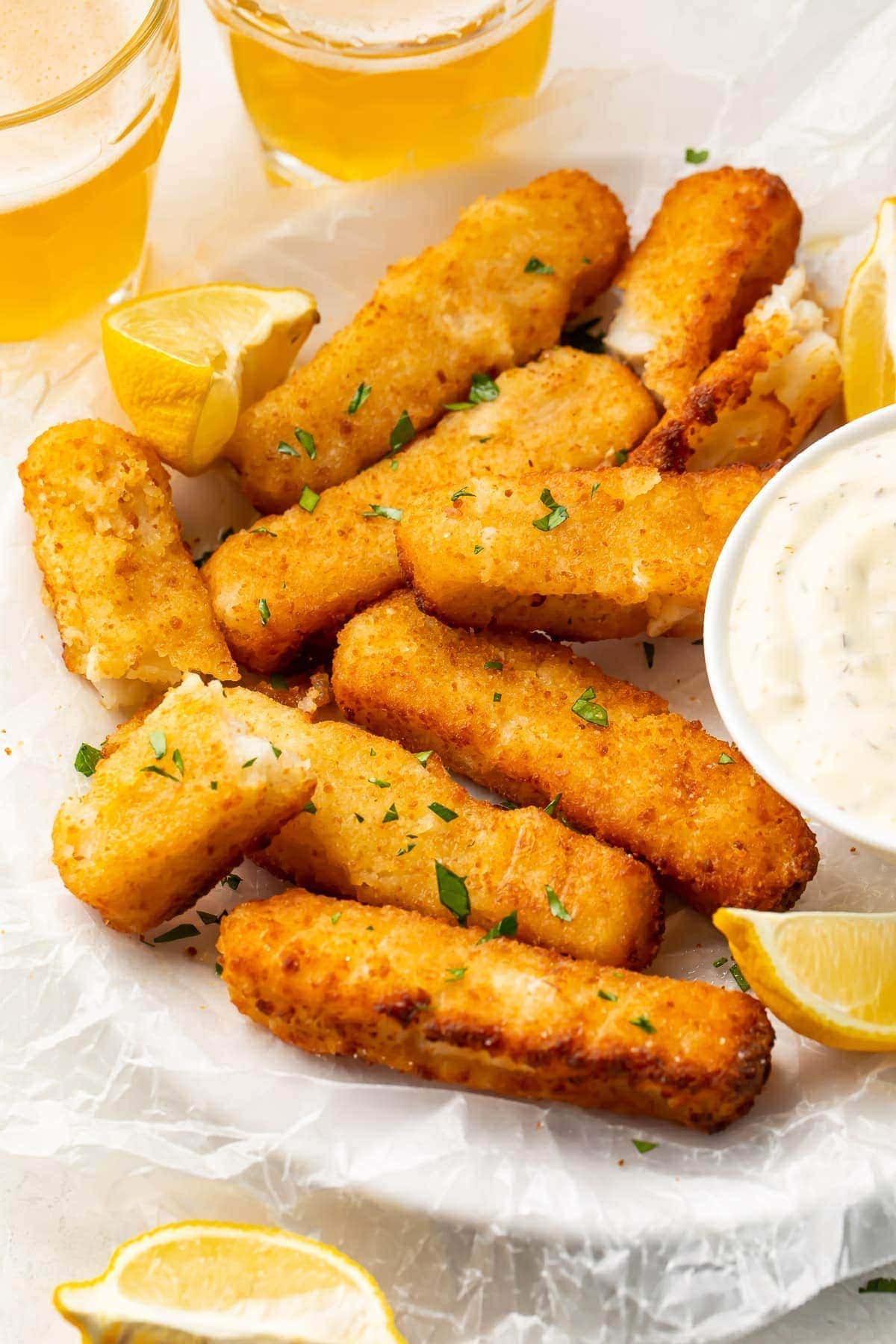 Air fried fish sticks on a white plate with dipping sauce