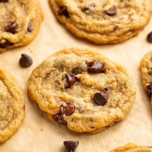 Angled view of vegan chocolate chip cookies on parchment paper