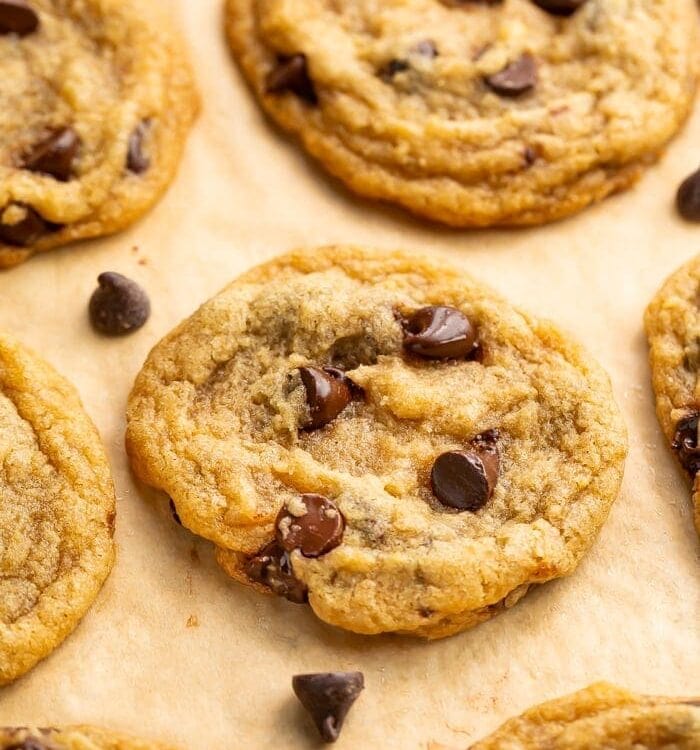 Angled view of vegan chocolate chip cookies on parchment paper