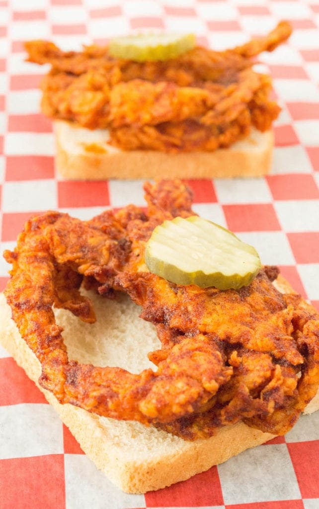 Fried and seasoned soft shell crab on a slice of white bread topped with a pickle