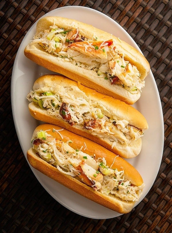 Three crab meat rolls angled on an oval white platter