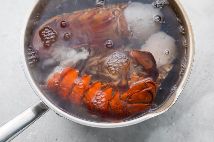 Boiling lobster tails in a large silver pot