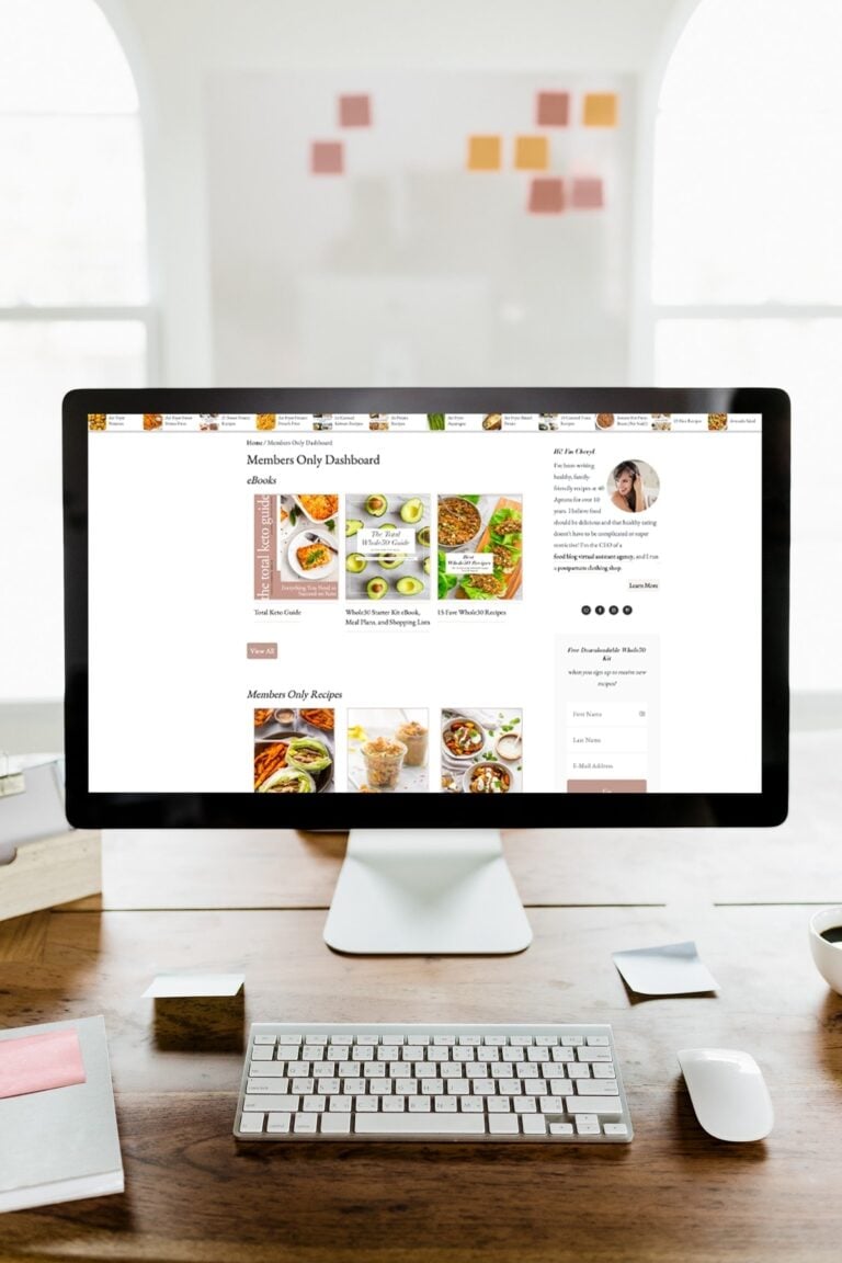 40 Aprons Premium on a desktop computer, on top of a wooden desk in front of a white wall bordered by two large windows with sunlight