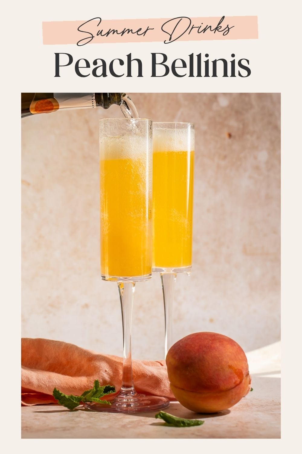 Prosecco being poured into two champagne flutes filled with golden peach puree, with a whole peach beside them