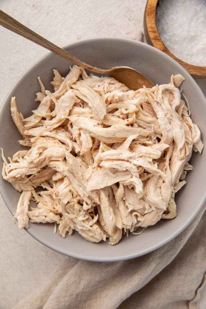 Zoomed out photo of shredded chicken in a bowl