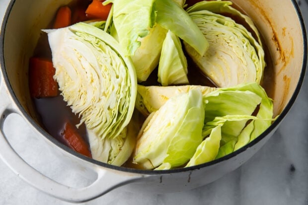 Cabbage and other vegetables with vegan corned beef in a large pot