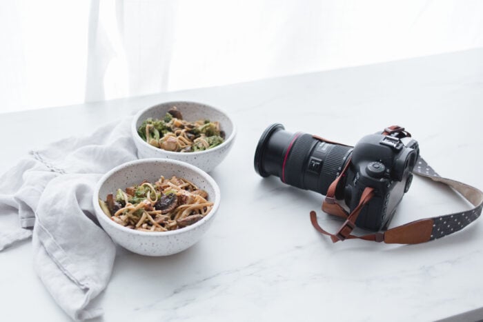 Digital camera next to two bowls of egg roll in a bowl