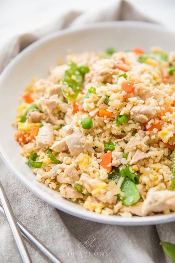 Chicken fried cauliflower rice in a white bowl