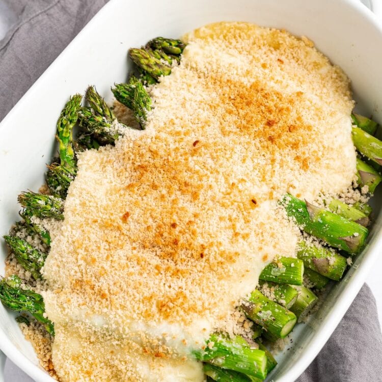Asparagus casserole in baking dish on top of a dish towel.