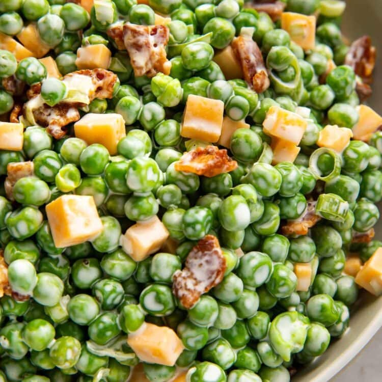 Pea salad with bacon, cheddar, and green onions in a large bowl