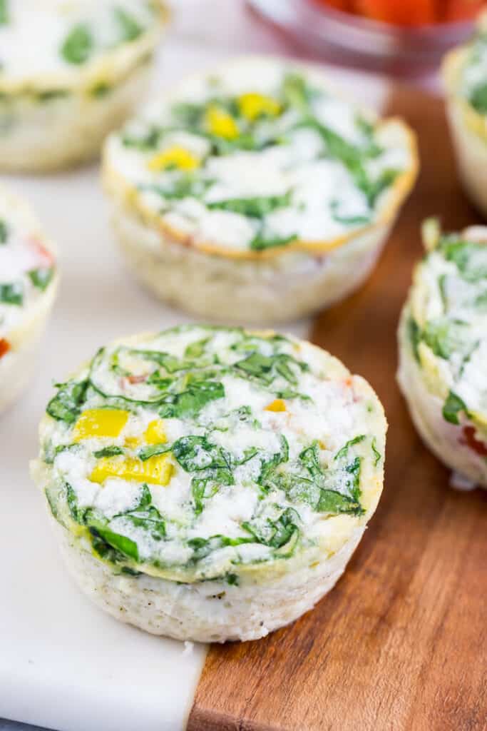 Egg white muffins with spinach on a wooden counter