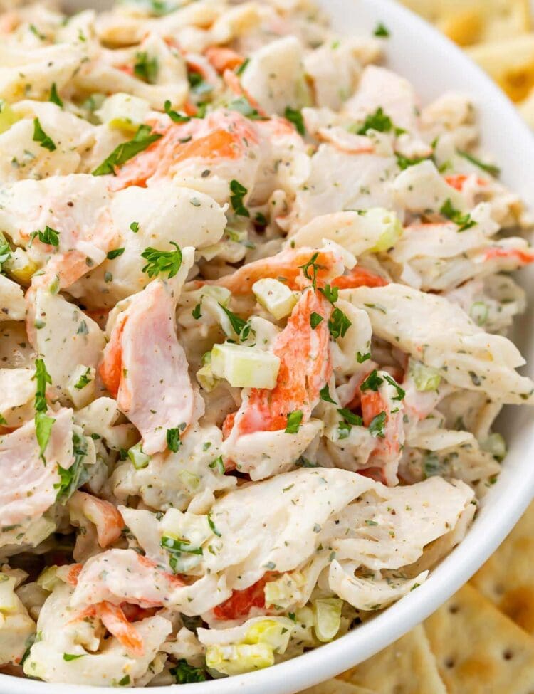Crab salad in a bowl with an array of saltine crackers