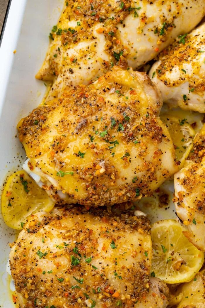 Lemon pepper chicken thighs in a white baking dish