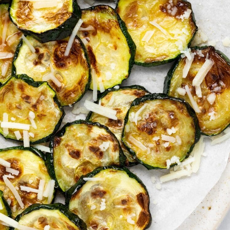 Overhead image of air fried zucchini slices with parmesan cheese on top.