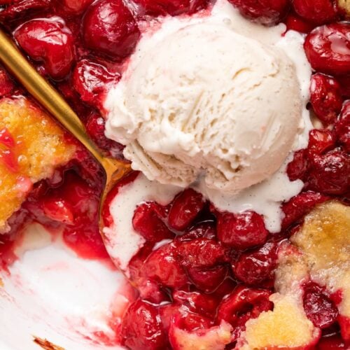 Cherry cobbler with a scoop of vanilla ice cream on top.