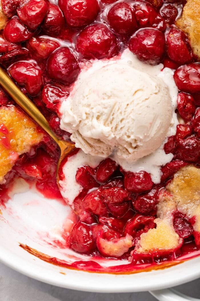 Cherry cobbler with a scoop of vanilla ice cream on top.