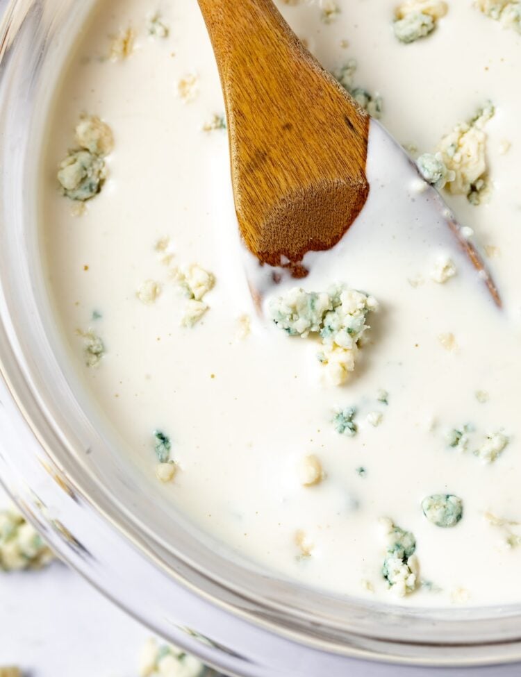 Roquefort dressing in a bowl with a wooden spoon.