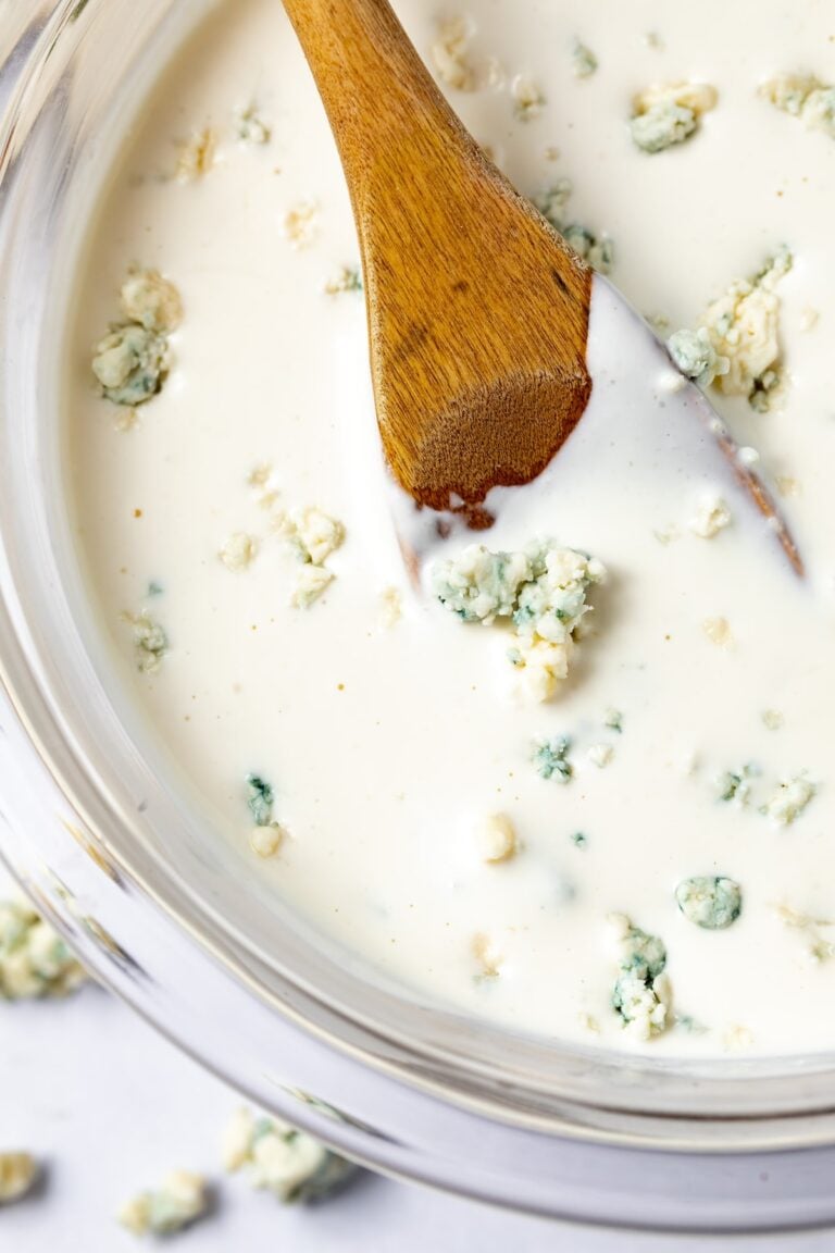 Roquefort dressing in a bowl with a wooden spoon.