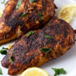Blackened chicken on a white plate with lemon wedge garnish - easy chicken recipes for dinners with few ingredients