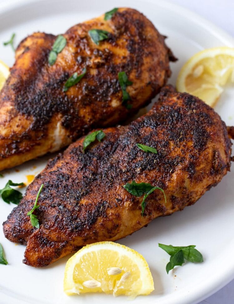 Blackened chicken on a white plate with lemon wedge garnish - easy chicken recipes for dinners with few ingredients