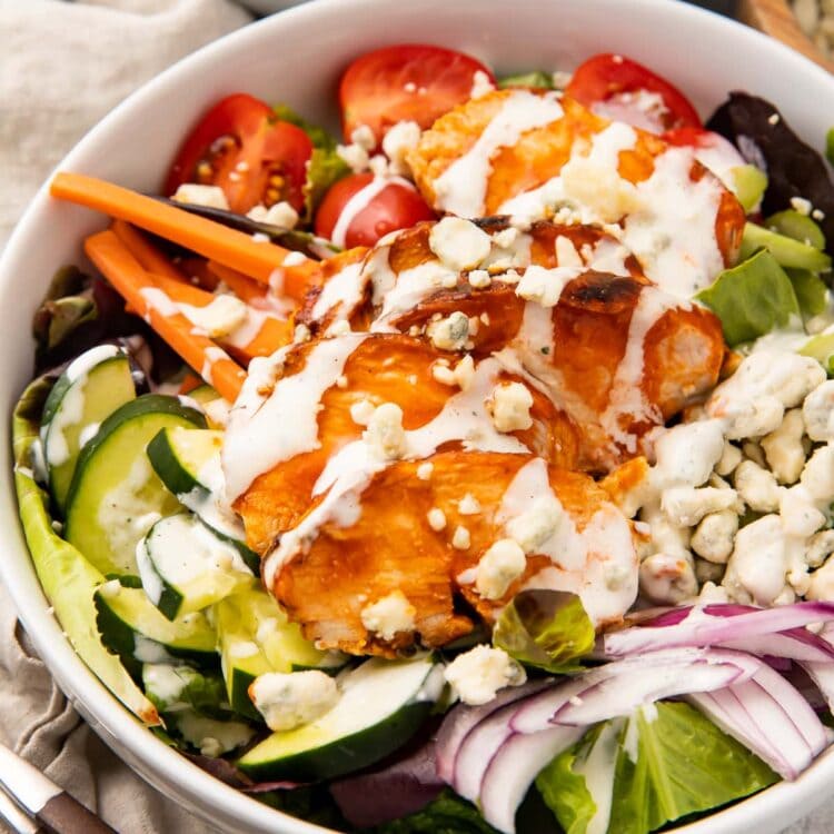 Buffalo chicken salad in a white bowl with ranch dressing