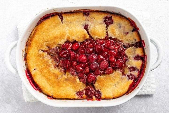 Baked cherry cobbler in a 9x13 baking dish resting on a countertop.