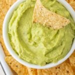 Guacamole dip with a tortilla chip stuck in it