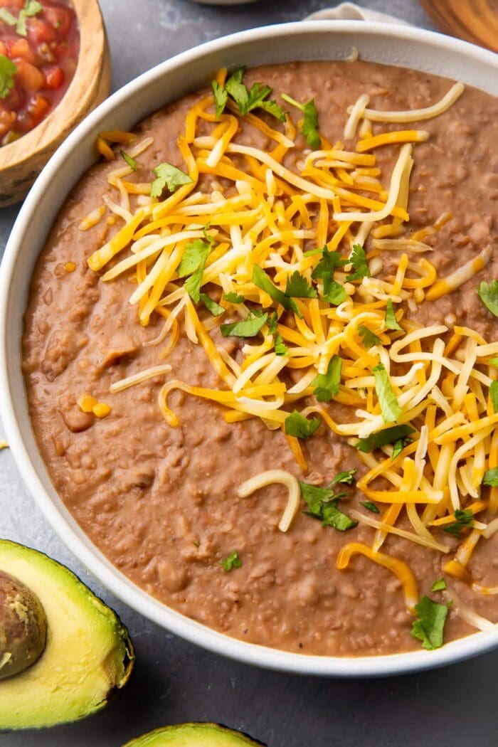 Instant Pot refried beans in a bowl topped with shredded cheese
