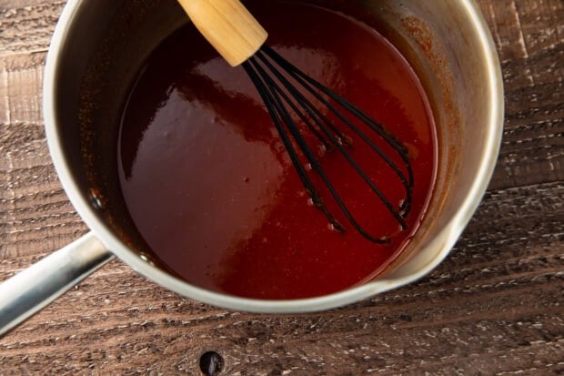 Keto bbq sauce in a saucepan with a whisk
