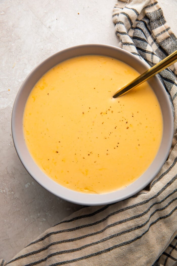 A bowl of keto cheese sauce on a table