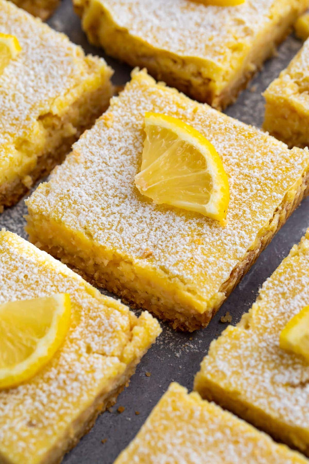 Close up of one keto lemon surrounded by keto lemon bars