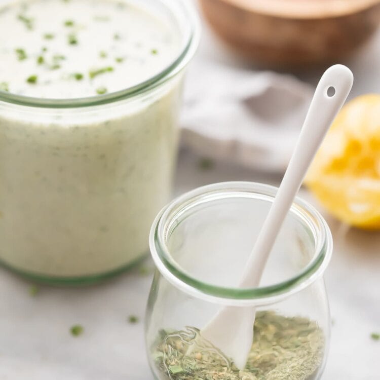 Ranch dressing mix in a glass jar next to a jar of ranch dressing