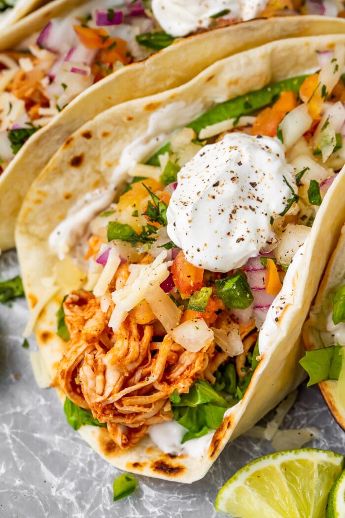 Close up of a shredded chicken taco with sour cream