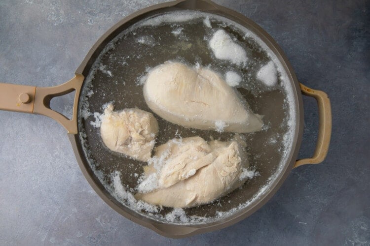Boiled chicken in saucepan of water
