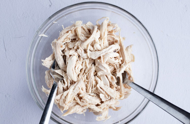 Shredded chicken in large glass bowl