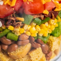 Close up image of cornbread salad layered in a dish.