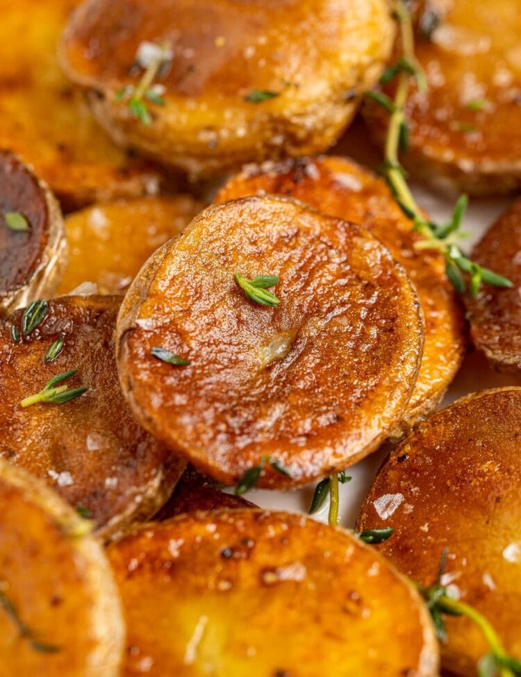 close up image of crispy pan fried potatoes sprinkled with fresh thyme
